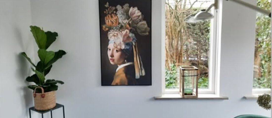 Hoek van de praktijkruimte met plant en schilderij bij het raam